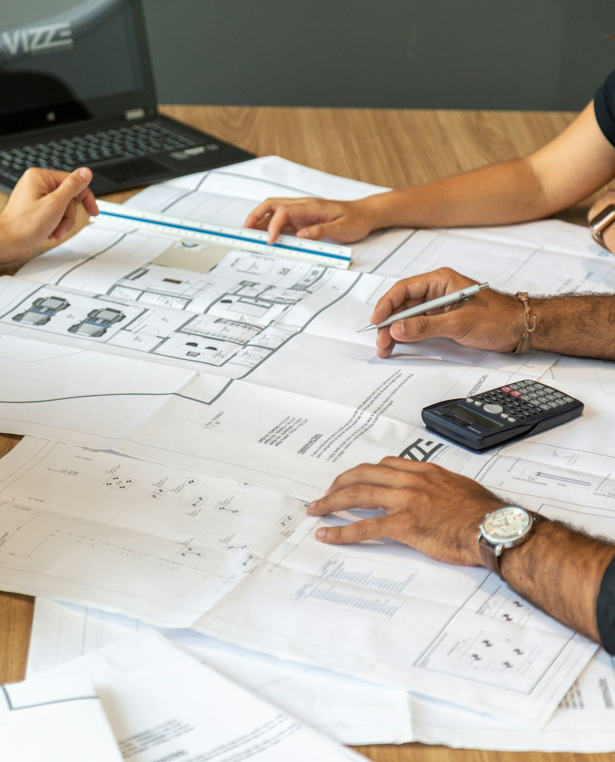 Hands resting on printed office layout plans.